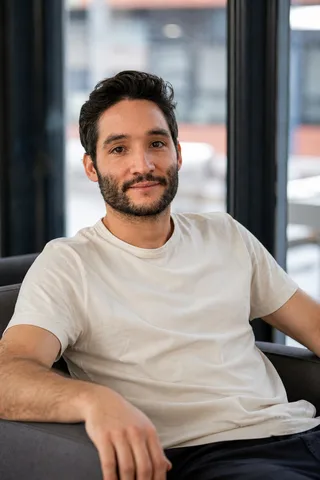 Photo générée d’un homme en t-shirt, assis près d’une baie vitrée
